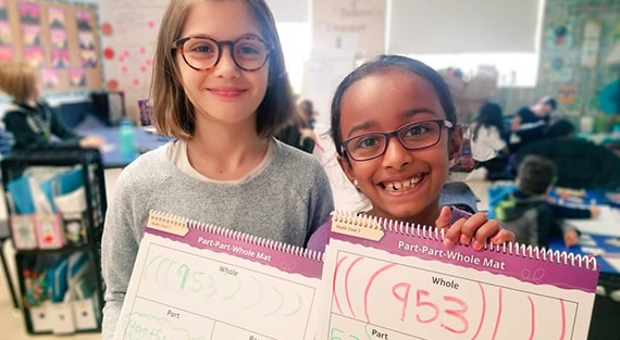 two girls holding up books
